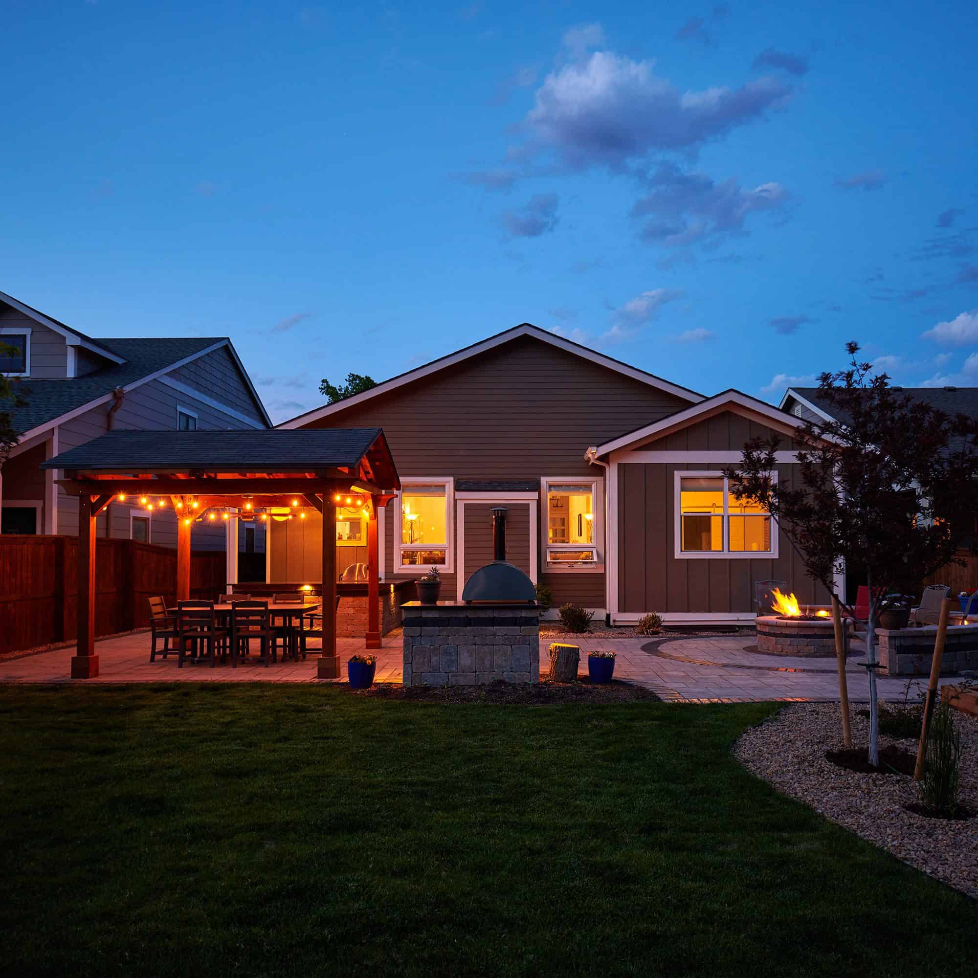 Full backyard landscape lighting at dusk in Lafayette, CO by Nature's Way Landscapes