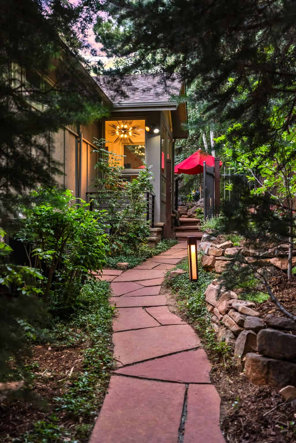 Flagstone garden path with bollard lighting at dusk in Boulder, CO by Nature's Way Landscapes