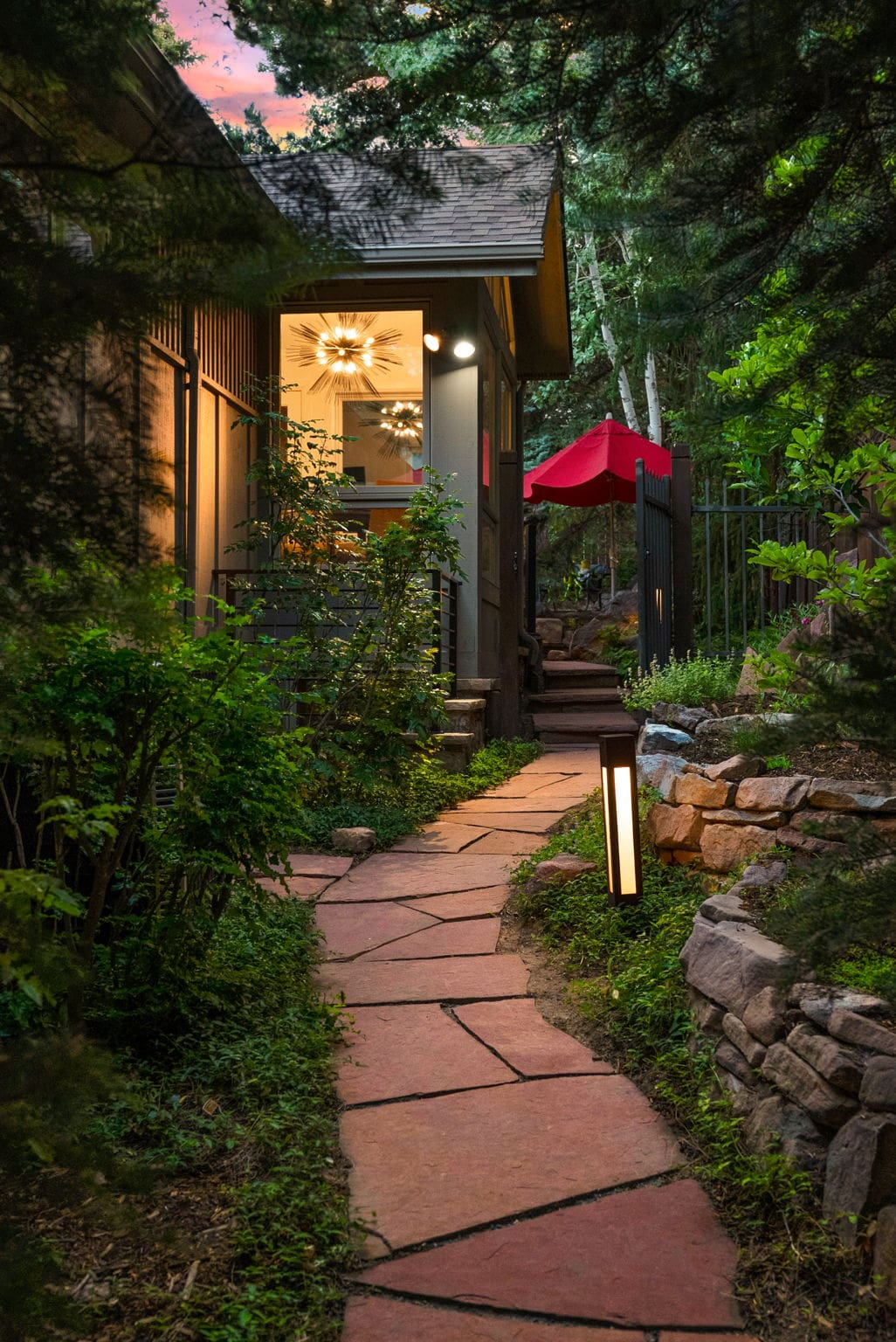 Garden path with landscape lighting at dusk in Boulder, CO by Nature's Way Landscapes
