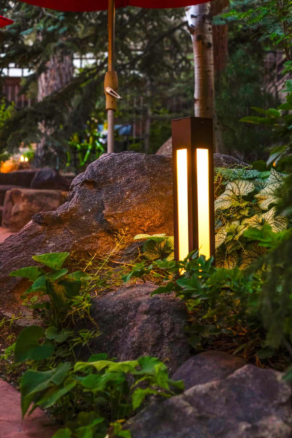 Bollard light fixture in garden landscape at dusk in Boulder, CO by Nature's Way Landscapes