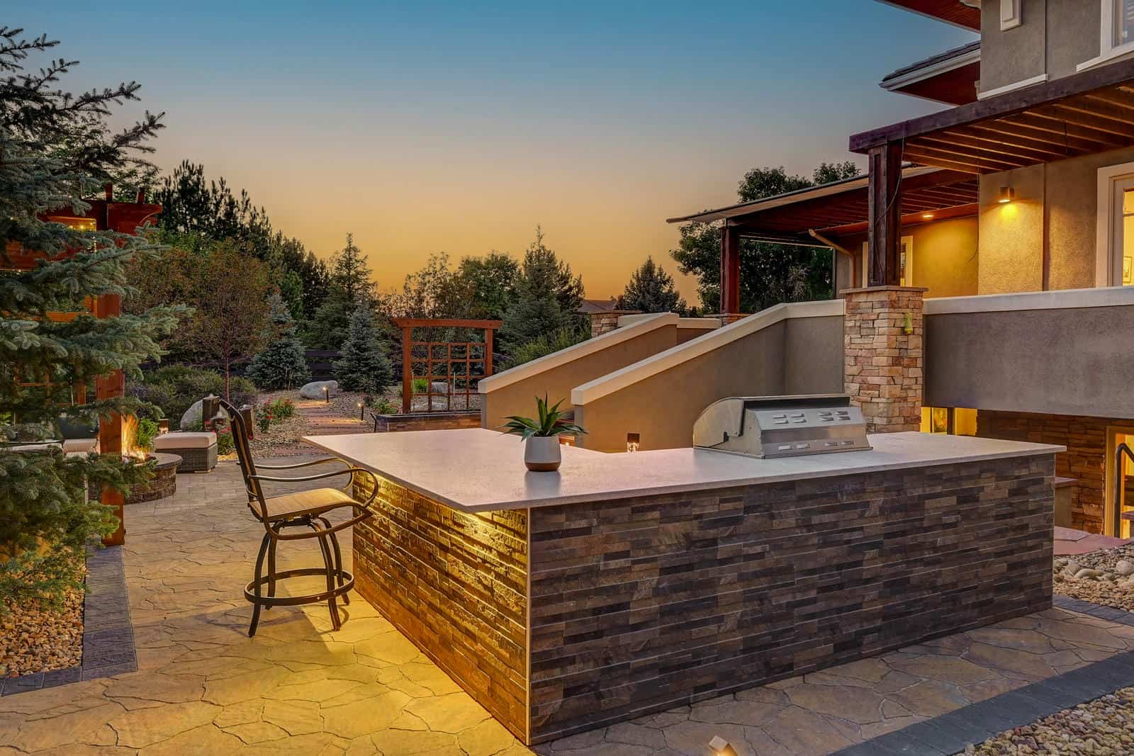 Custom patio and hot tub installation at dusk in Boulder, CO by Nature's Way Landscapes