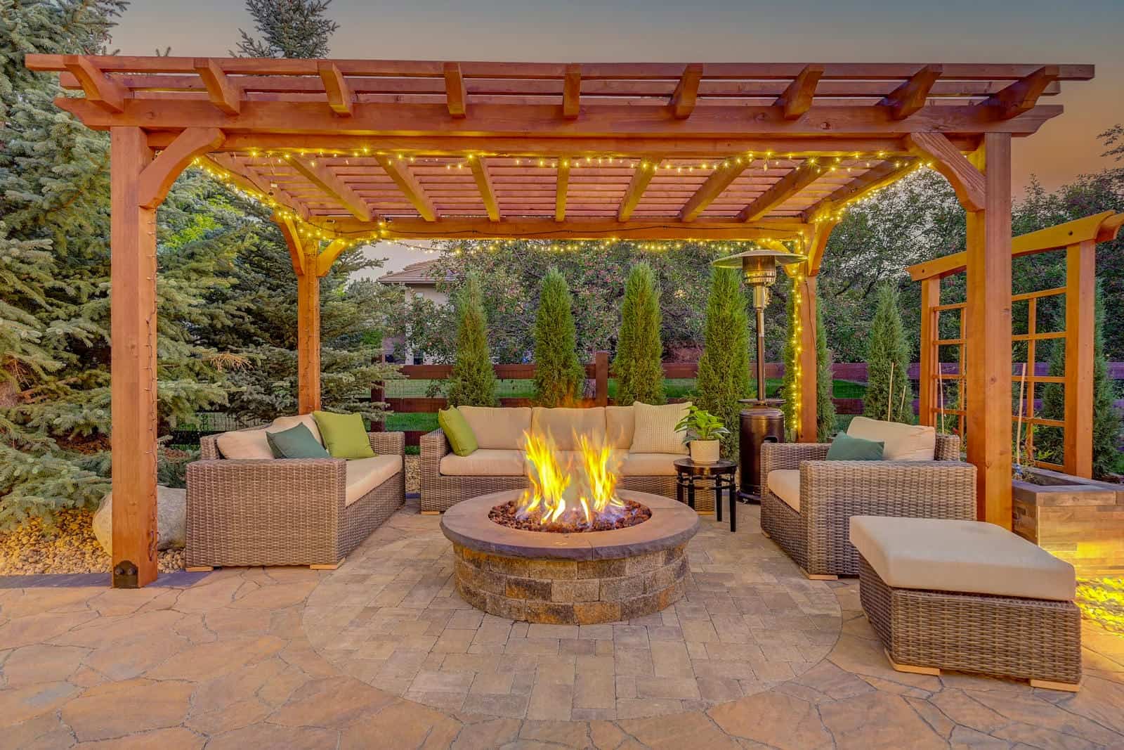 Pergola and fire pit patio installation at evening in Boulder, CO by Nature's Way Landscapes