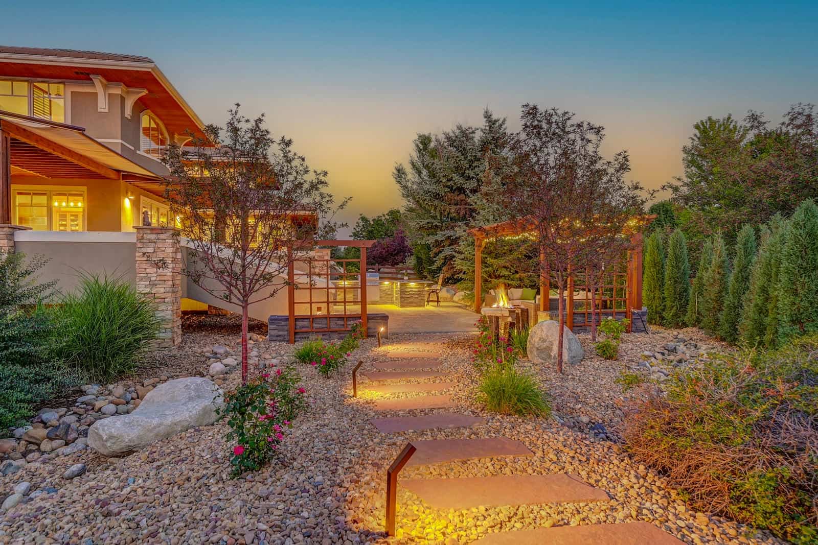 Pergola and fire pit patio at dusk in Boulder, CO by Nature's Way Landscapes