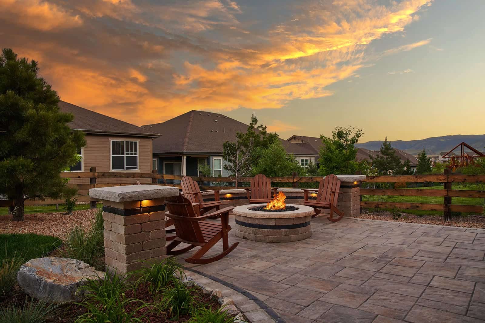Custom fire pit and patio installation at sunset in Broomfield, CO by Nature's Way Landscapes