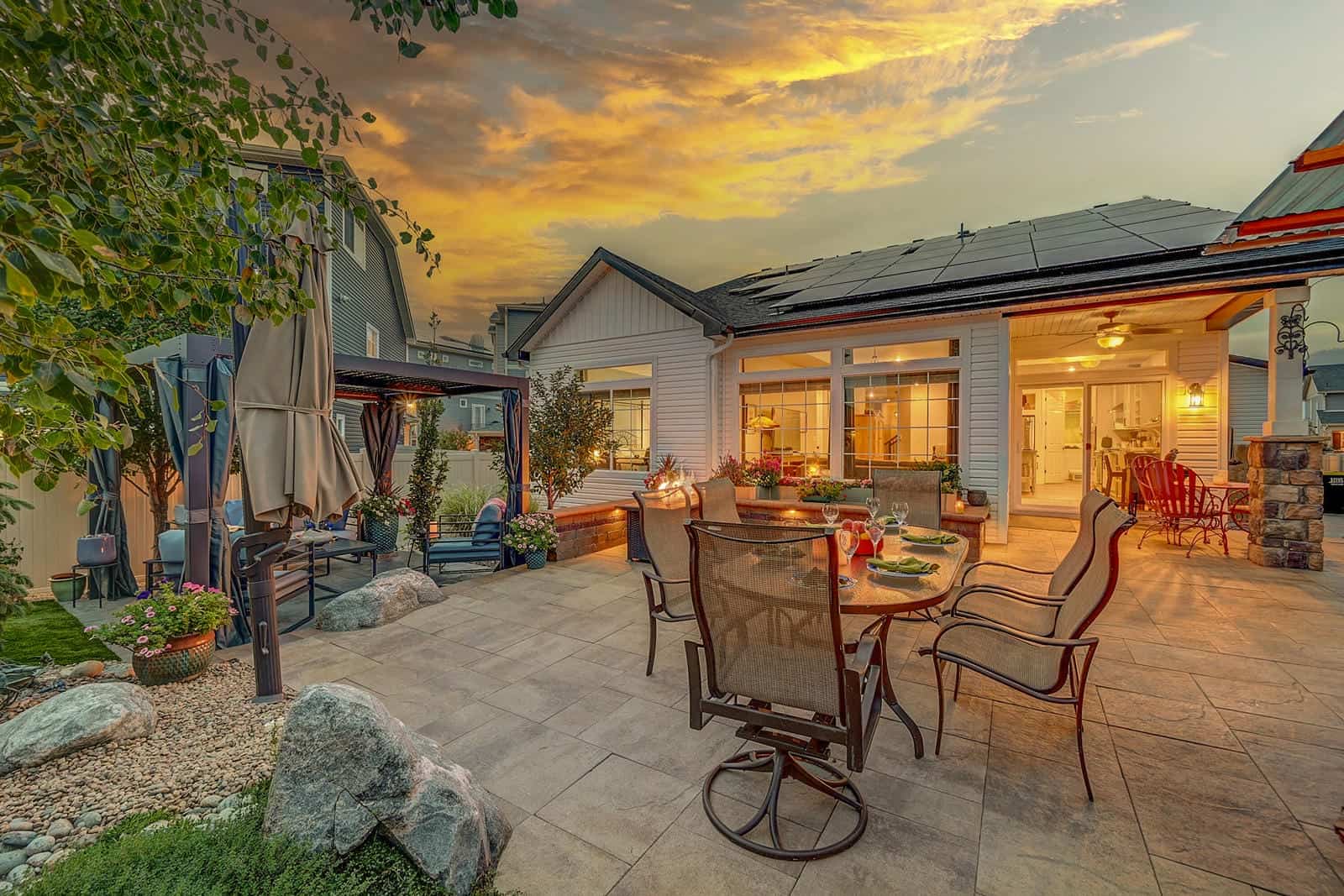 Custom patio and outdoor living space at sunset in Broomfield, CO by Nature's Way Landscapes