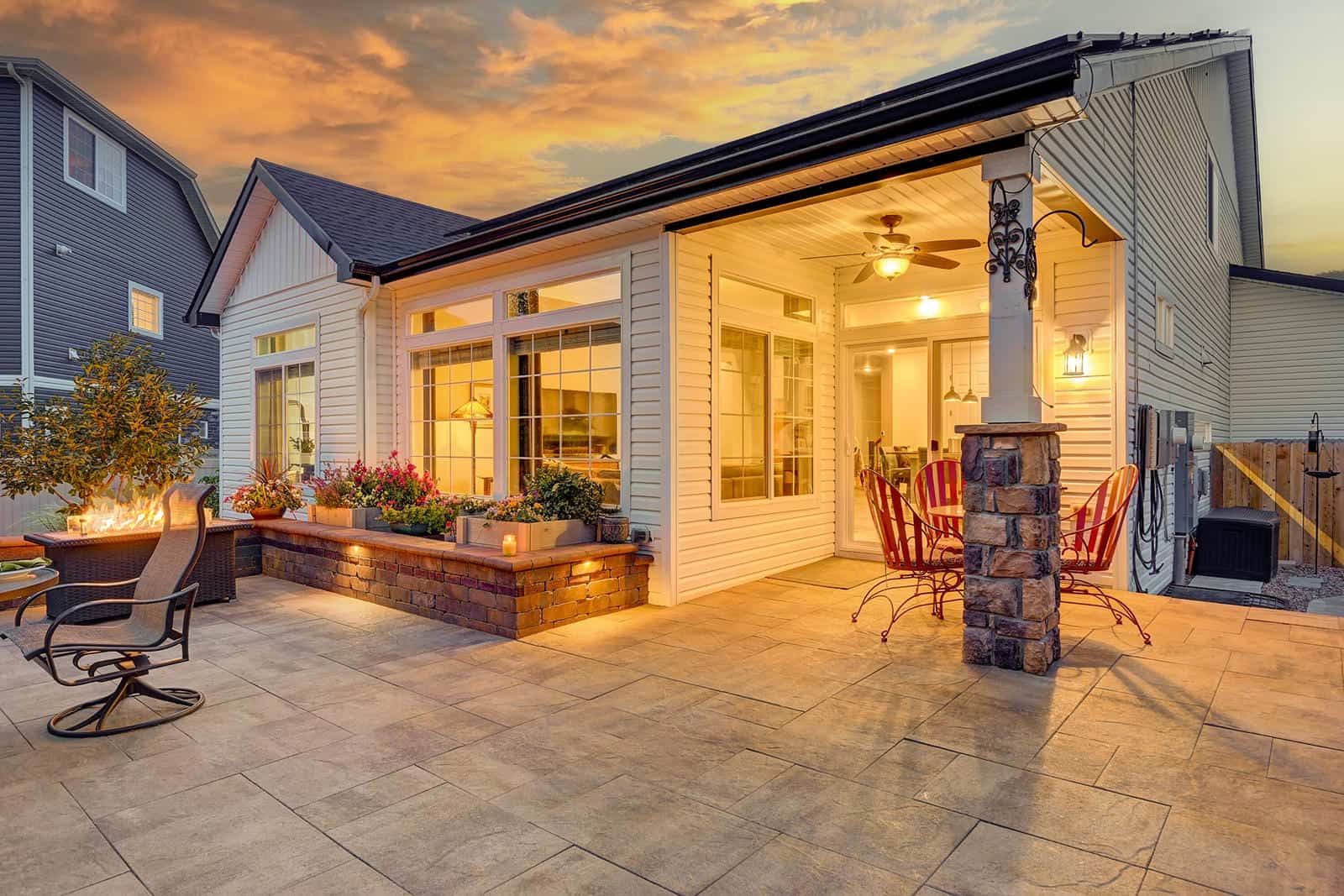 Outdoor patio with fire table at golden hour in Broomfield, CO by Nature's Way Landscapes