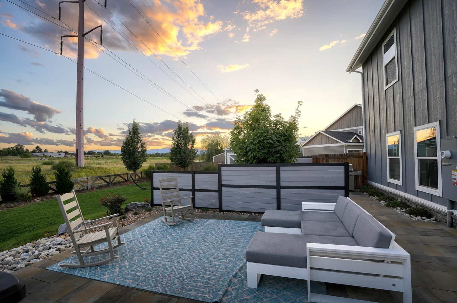 Outdoor patio with Adirondack chairs at evening in Erie, CO by Nature's Way Landscapes