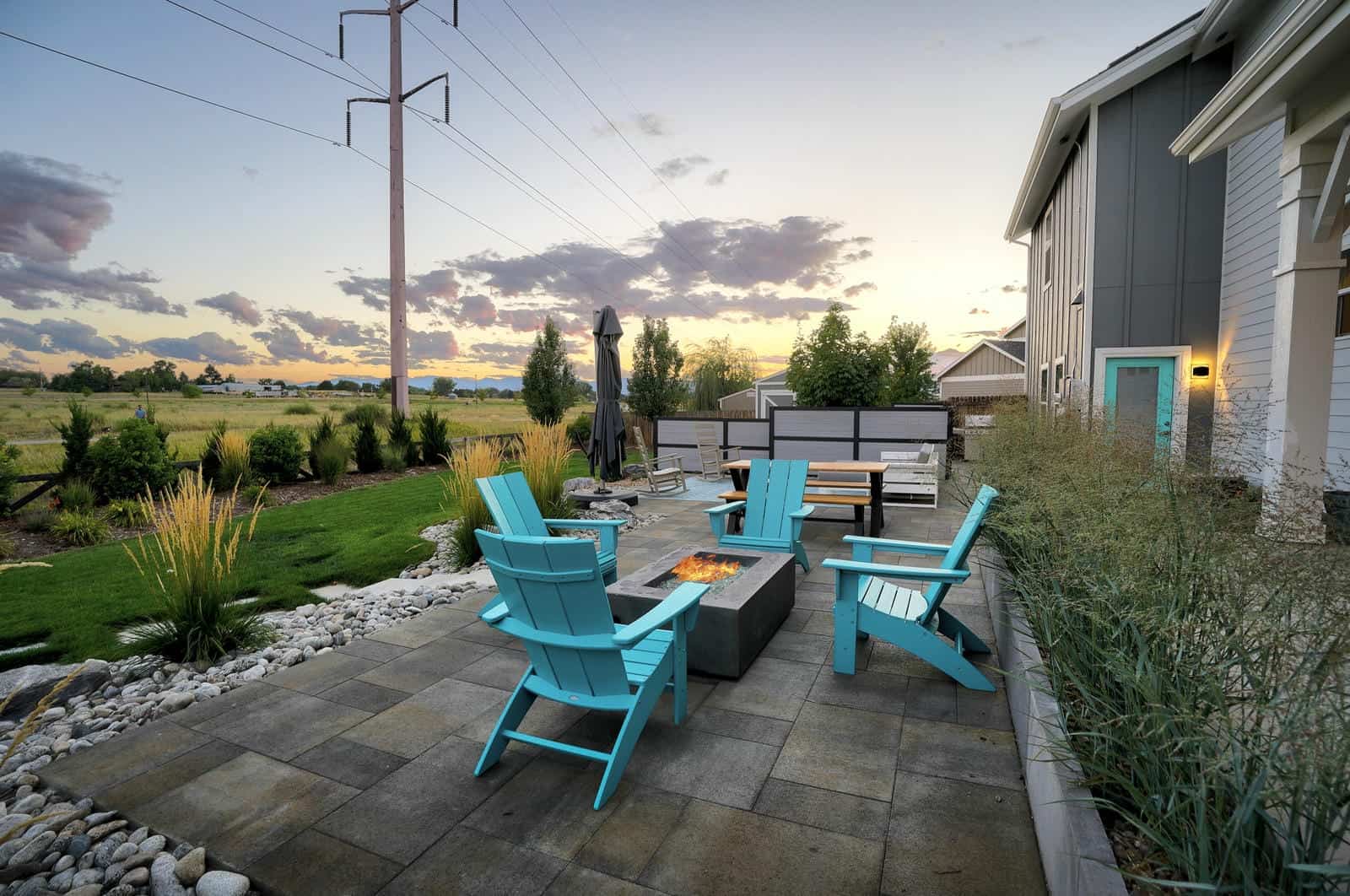 Custom patio and outdoor living space at dramatic sunset in Erie, CO by Nature's Way Landscapes