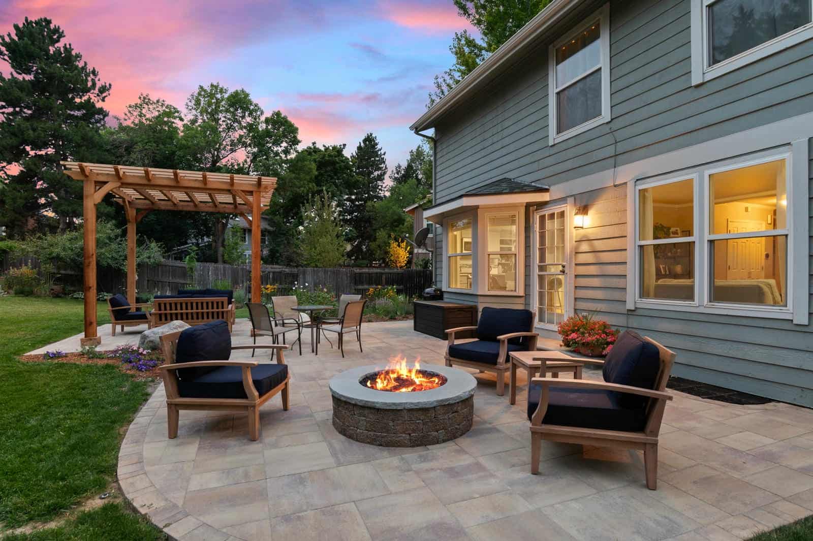 Pergola and fire pit patio at dusk in Westminster, CO by Nature's Way Landscapes